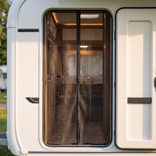 Golden retriever walking out through the magnetic fly screen door of a caravan